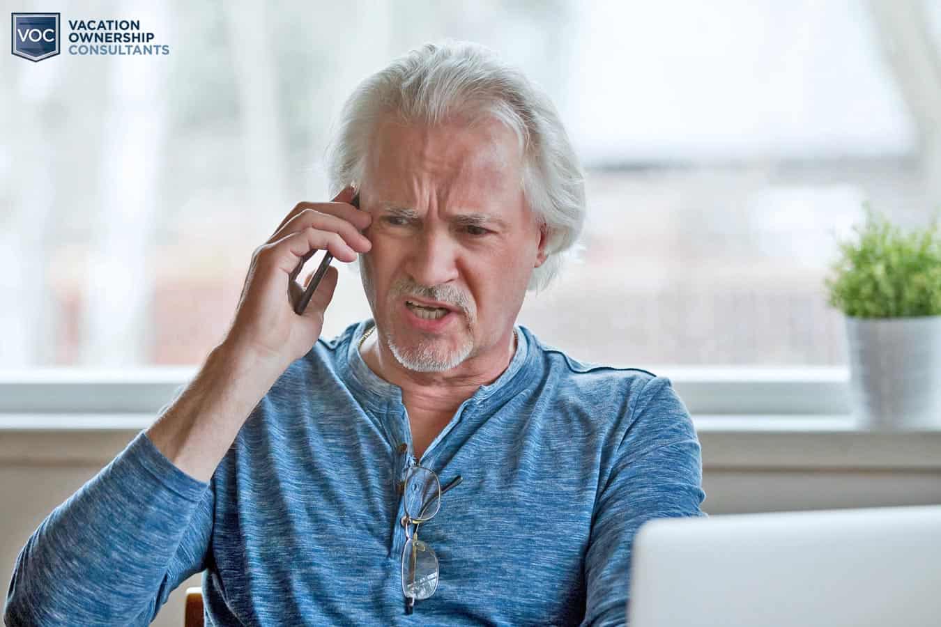 man-on-phone-with-collections-agency-from-destination-travel-resort-after-walking-away-from-timeshare-maintenance-fees-considering-cancellation-services-with-VOC