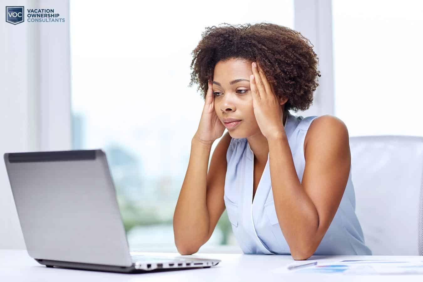 woman-looking-depressed-at-computer-wondering-what-to-do-with-her-timeshare-purhases-and-how-to-get-rid-of-them
