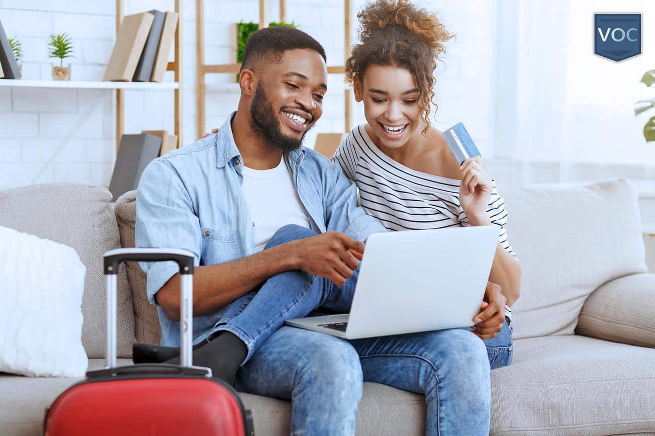 african-american-couple-on-couch-looking-at-computer-thinking-about-buying-a-timeshare-for-traveling