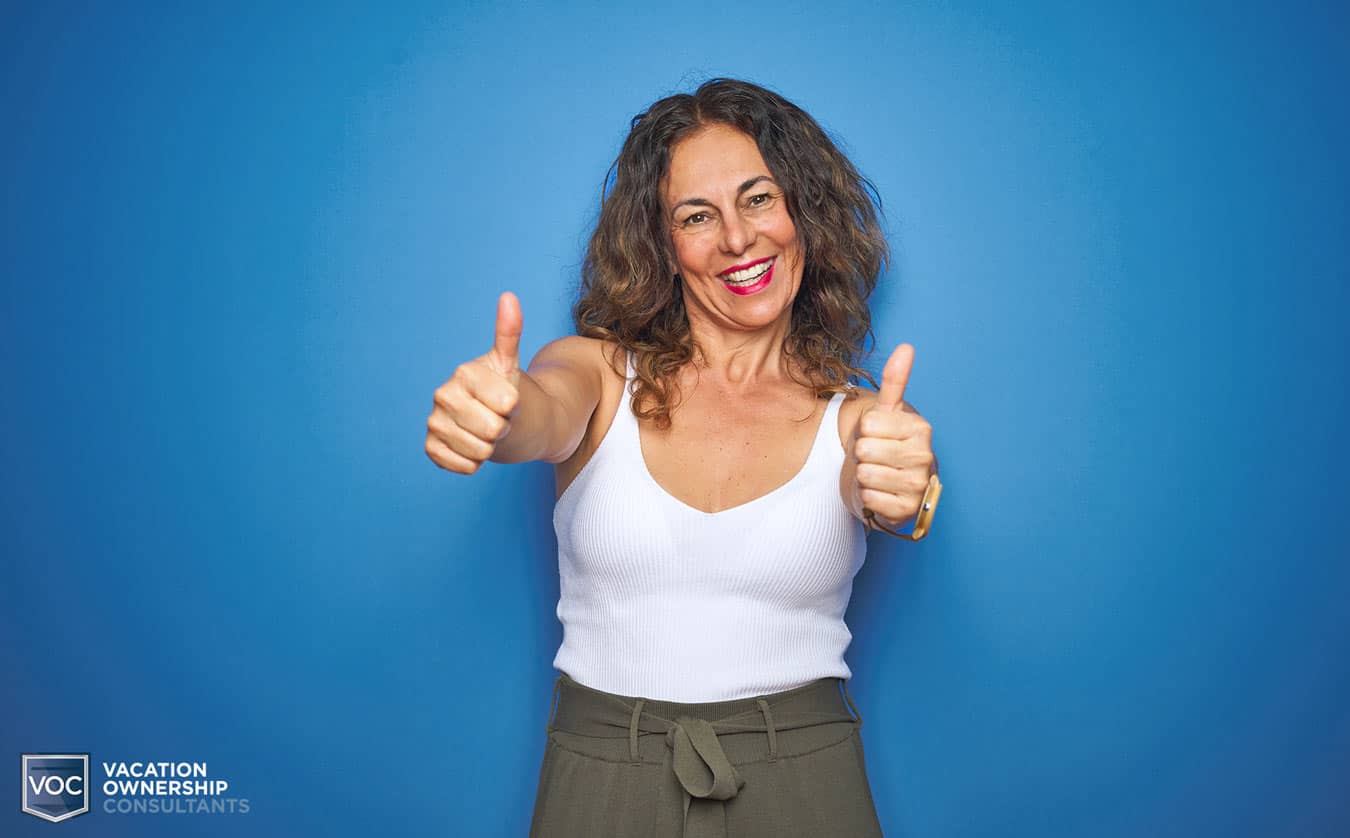 blue-background-woman-giving-thumbs-up-to-timeshare-exit-company-voc-for-helping-her-avoid-timeshare-interval-excahnge