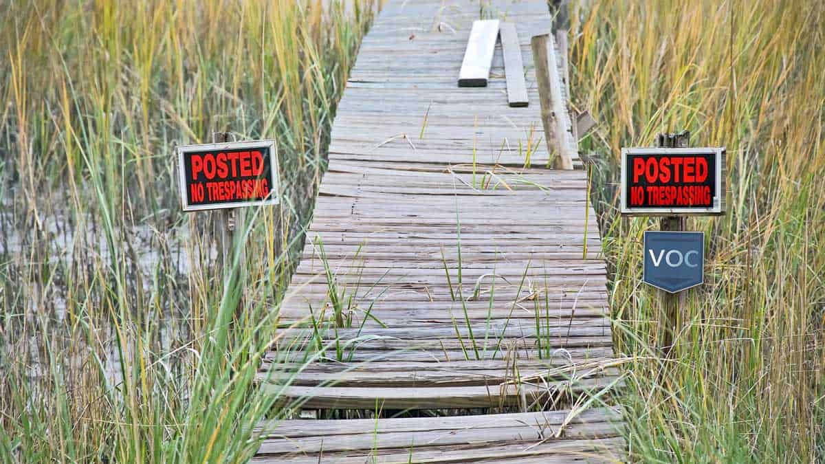 broken-down-dock-to-atlantic-ocean-in-myrtle-beach-south-carolina-at-failed-timeshare-resort-named-sand-castle-south-no-trespassing-signs