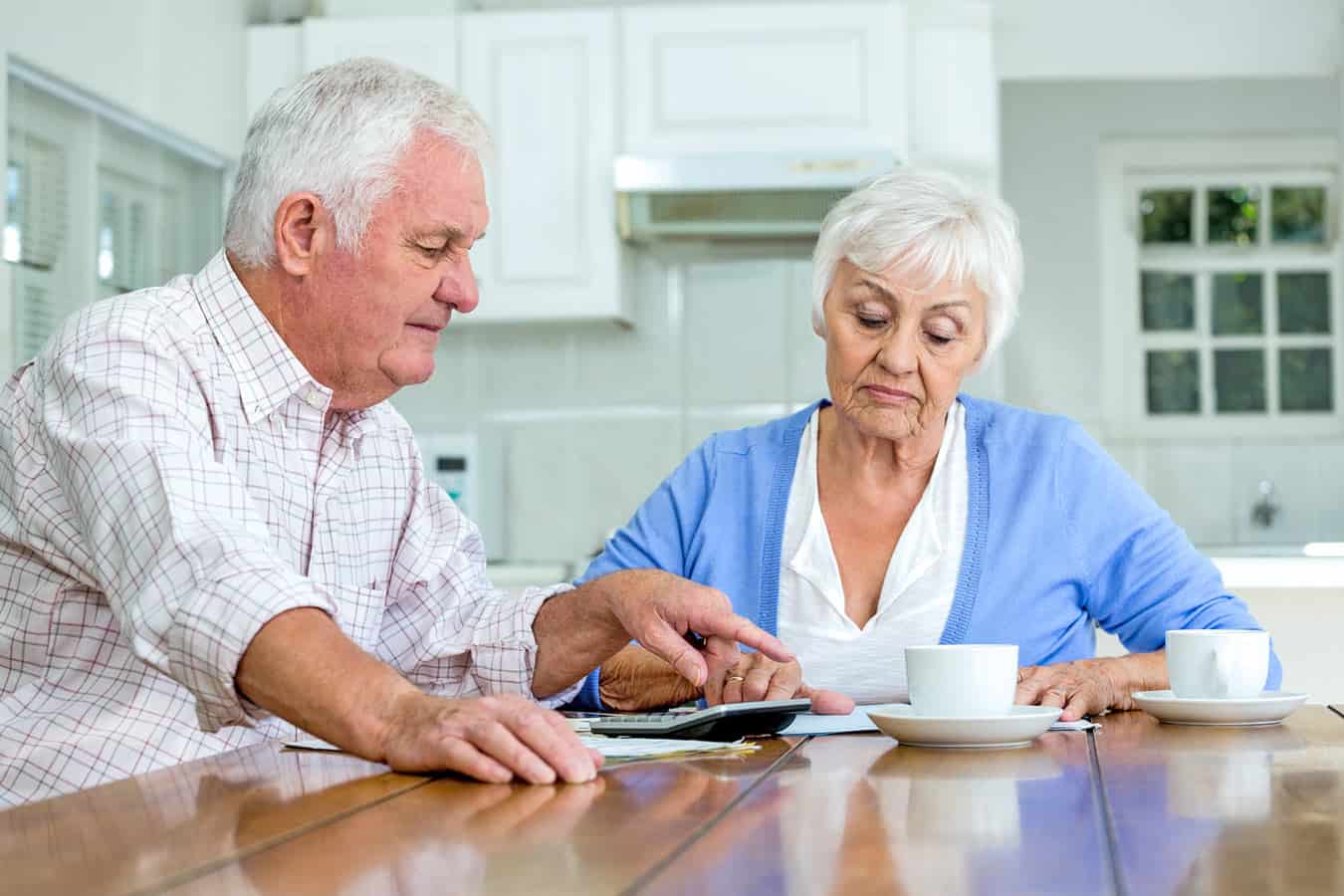 elderly-couple-at-kitchen-table-discussing-finances-regarding-timeshare-ownership-and-bankruptcy