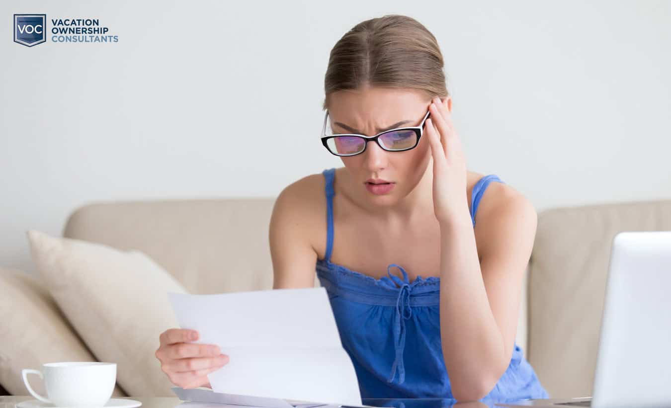 young-lady-in-blue-with-reading-glasses-checking-out-paperwork-for-timeshare-perpetuity-and-learning-resort-is-smearing-exit-companies