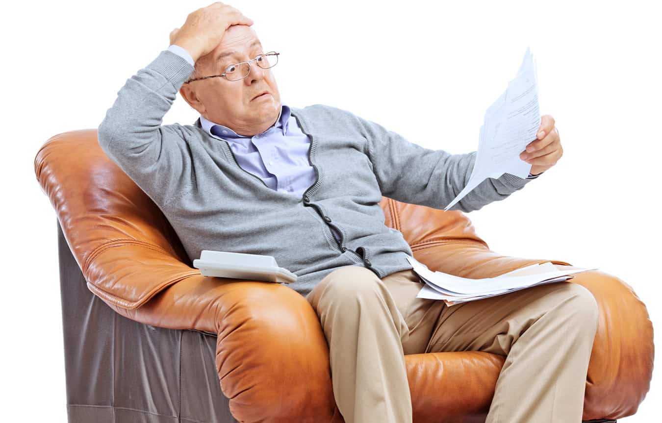 elderly-man-in-recliner-going-over-vacation-ownership-bills-and-credit-card-statements-with-resort-payments