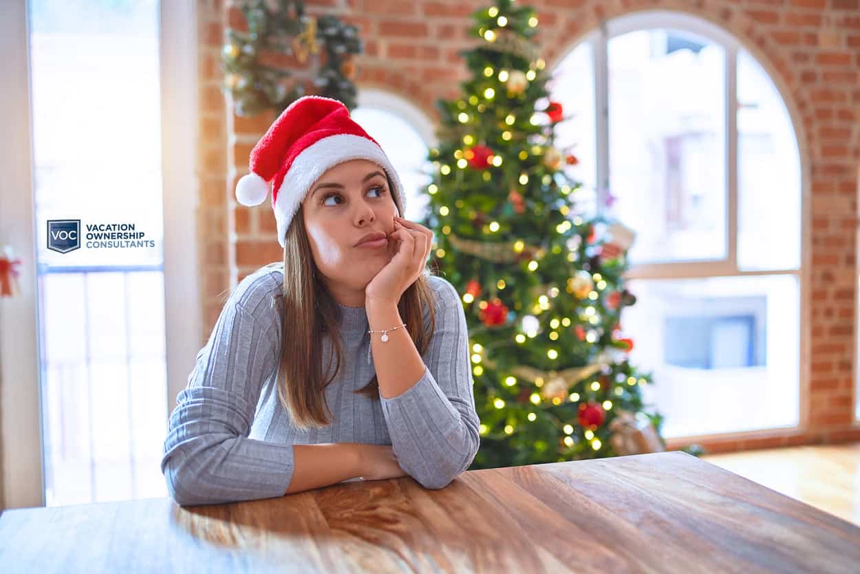 woman-by-christmas-tree-in-kitchen-thinking-about-giving-timeshare-vacation-up-for-the-holidays