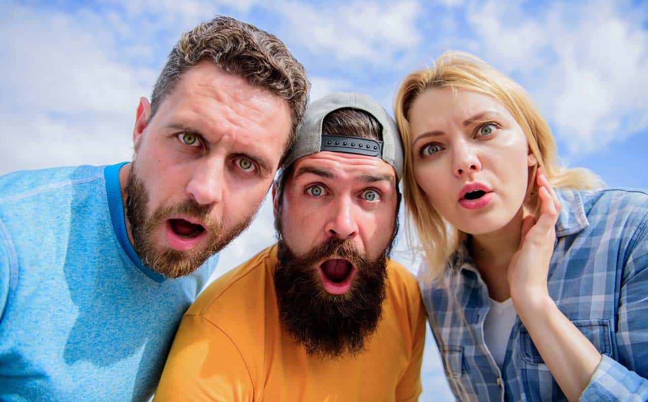 shocked-men-and-one-woman-with-cloudy-sky-background-gawking-at-screen-surprised-by-what-they-see