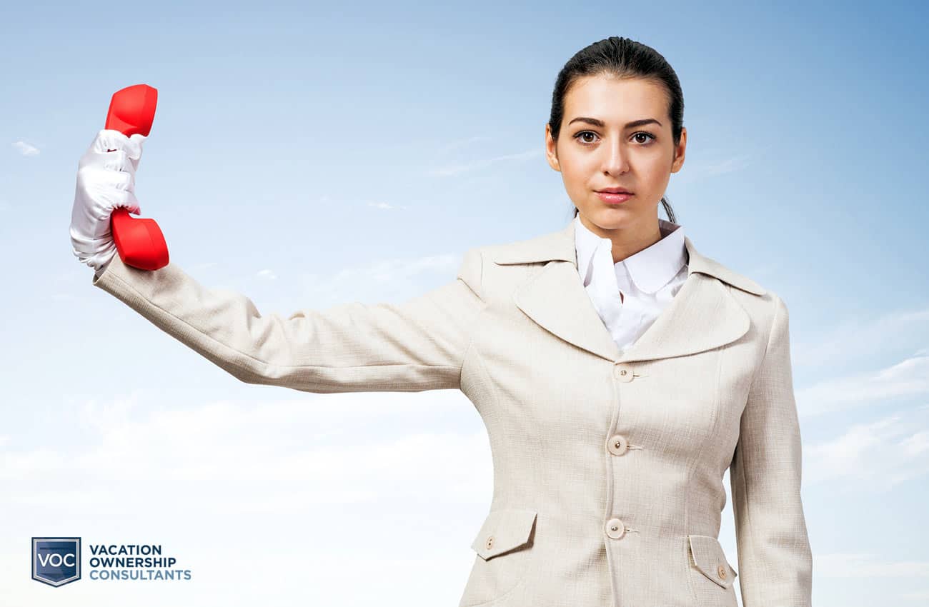 younger-woman-gloves-white-suit-holding-red-rotary-phone-receiver-with-sky-background-insinuating-sales-teams-refusal-tolisten-to-vacation-owners