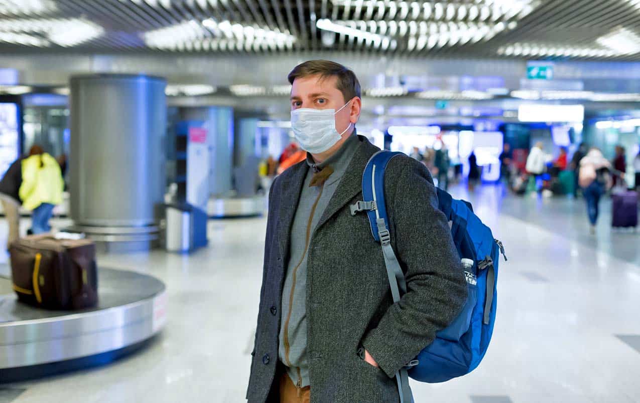 man-walking-through-airport-concerned-with-the-impact-of-coronavirus-on-travel-industry
