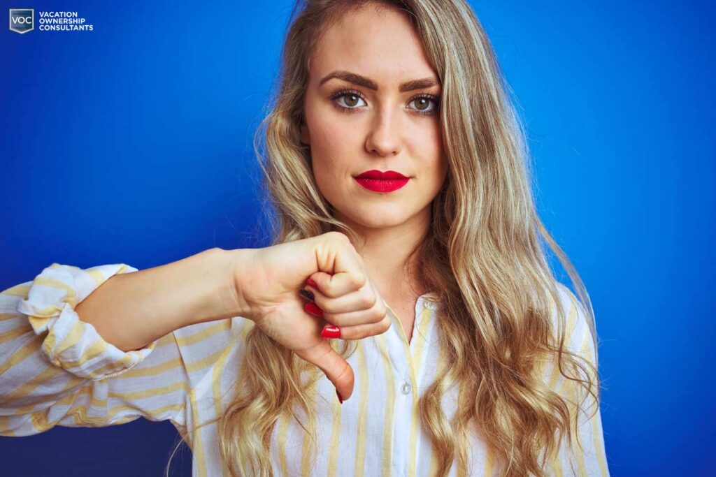 bright-red-lipstick-gal-serious-look-straight-into-camera-with-sign-of-disapproval-when-seeking-timeshare-relief-services-not-met-blue-background