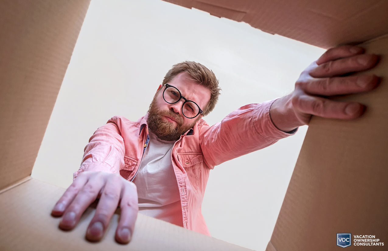 hipster-white-man-looking-into-box-expecting-something-better-than-what-arrived-similar-to-vacation-unit