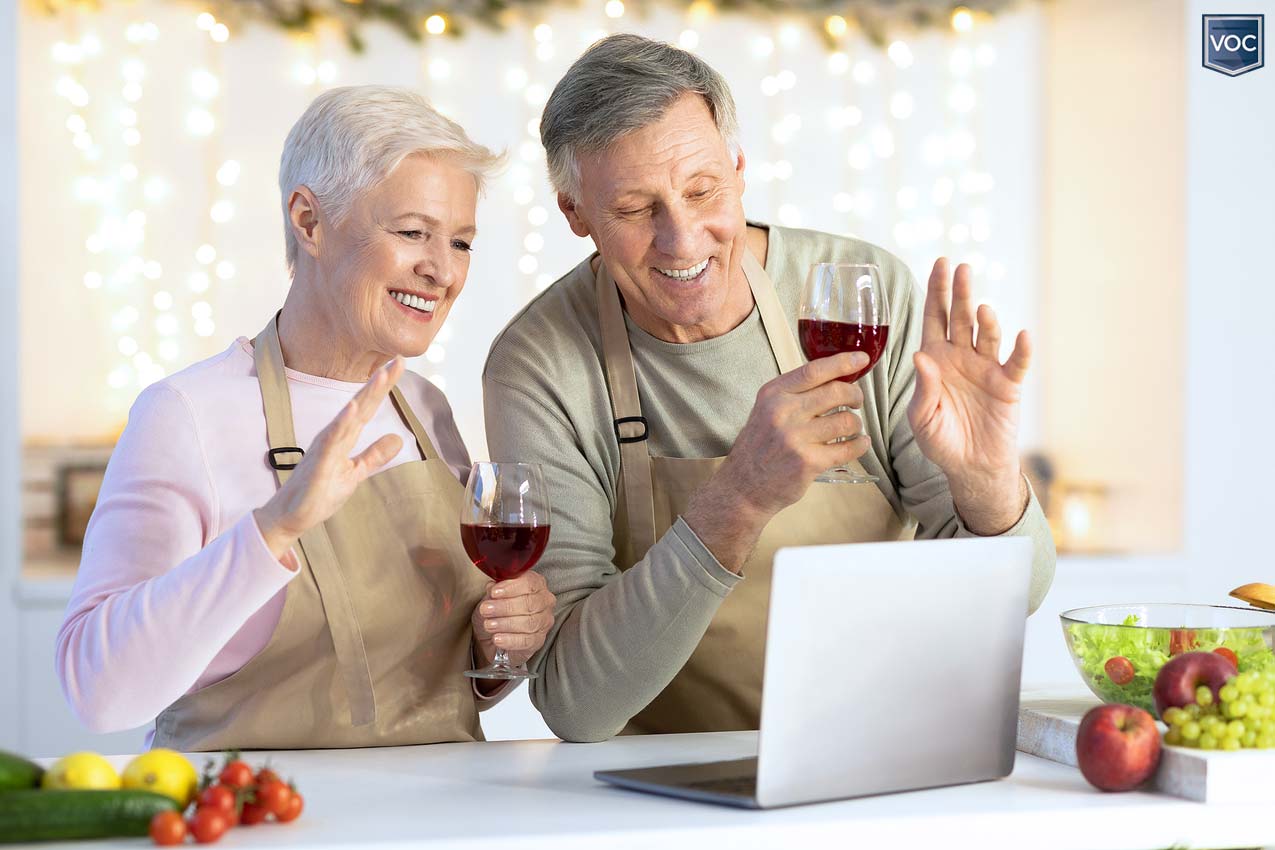 grandparents-drinking-red-wine-in-kitchen-during-computer-video-chat-with-family-members-due-to-travel-restrictions-during-holiday-season-2020-ushering-communism