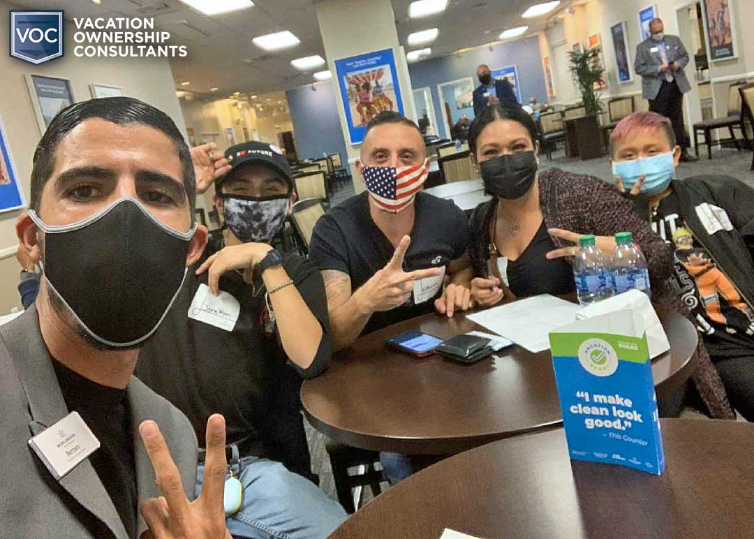 latino family seated with resort package salesman with masks and peace sign as they're being scammed by timeshare company in las vegas
