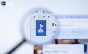 magnifying glass zooming in on the better business bureau logo on website listing during research session for timeshare owners and potential scams in the industry marketplace online