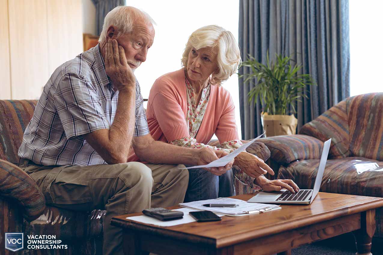 grandfather seems unhappy with what grandma is finding on the computer as they budget expenses and consider timeshare exit alone