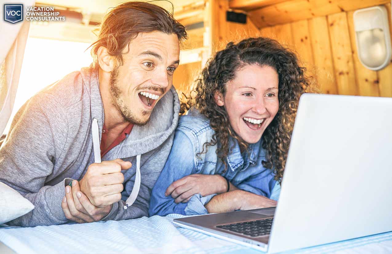 astonished couple gazing at computer screen in awe of vacation ownership deals they were sent via email during the covid hoax pandemic tricked into buying something they don't need and can't use